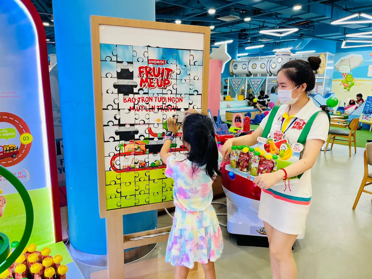 PG Fruit Me Up mời một bé chơi game xếp hình tại booth trong khu vui chơi