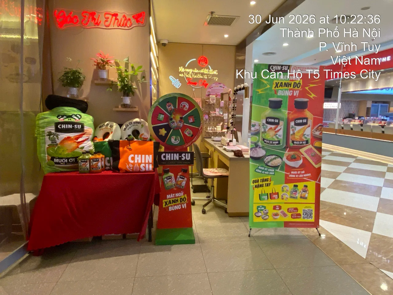 Khu hoạt động tại Haidilao Times City với vòng quay, standee chương trình và bàn trưng bày quà