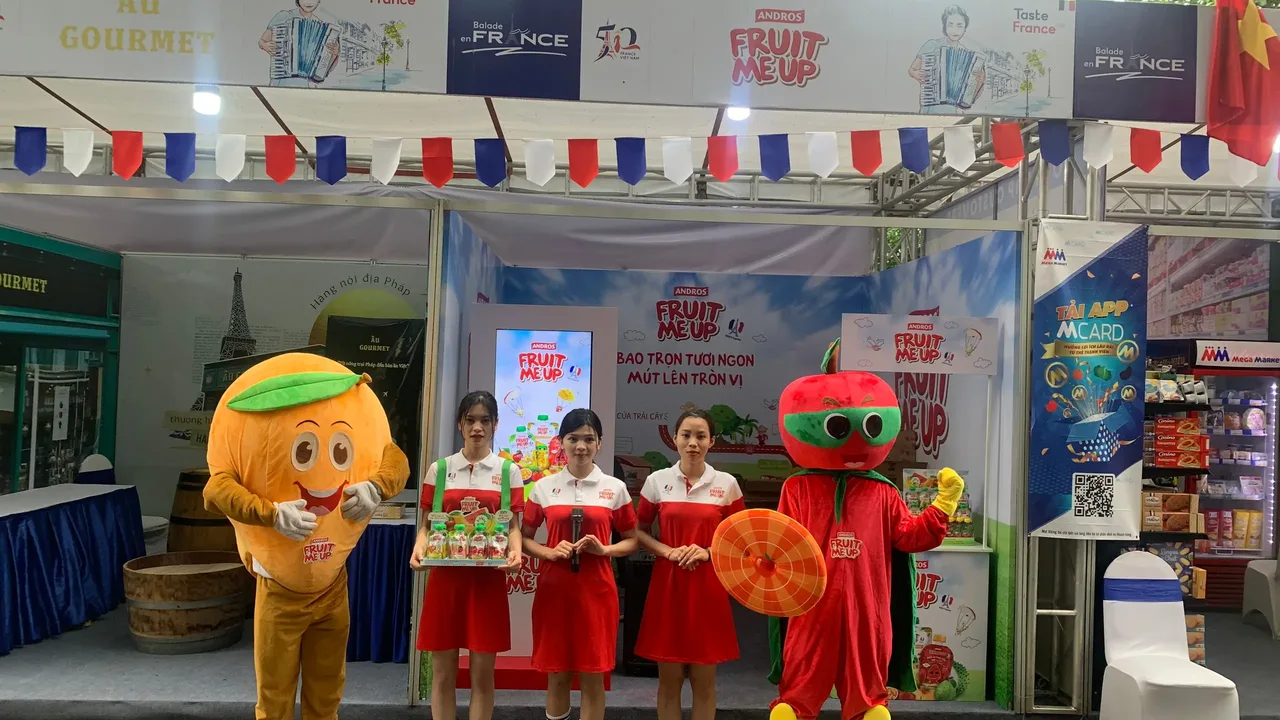 Hai mascot trái cây và ba PG Fruit Me Up trước booth tại French Food Festival Hà Nội