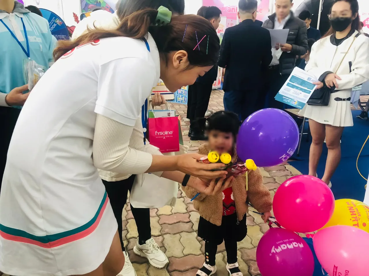 PG Fruit Me Up đưa sản phẩm cho một bé tại sự kiện mẹ và bé của Kids Plaza