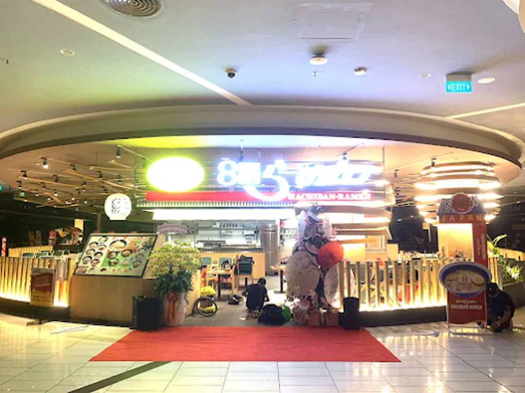 Khu vực trước cửa nhà hàng Hachiban Ramen trong lúc setup, với thảm đỏ, khung check-in Ramen Time và hoa khai trương