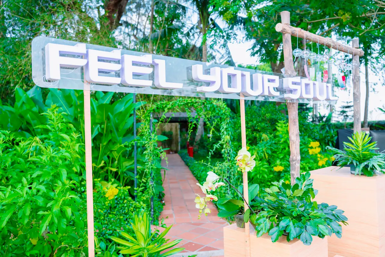 Lối dẫn vào khu vườn với chuông gió và bảng chữ Feel Your Soul