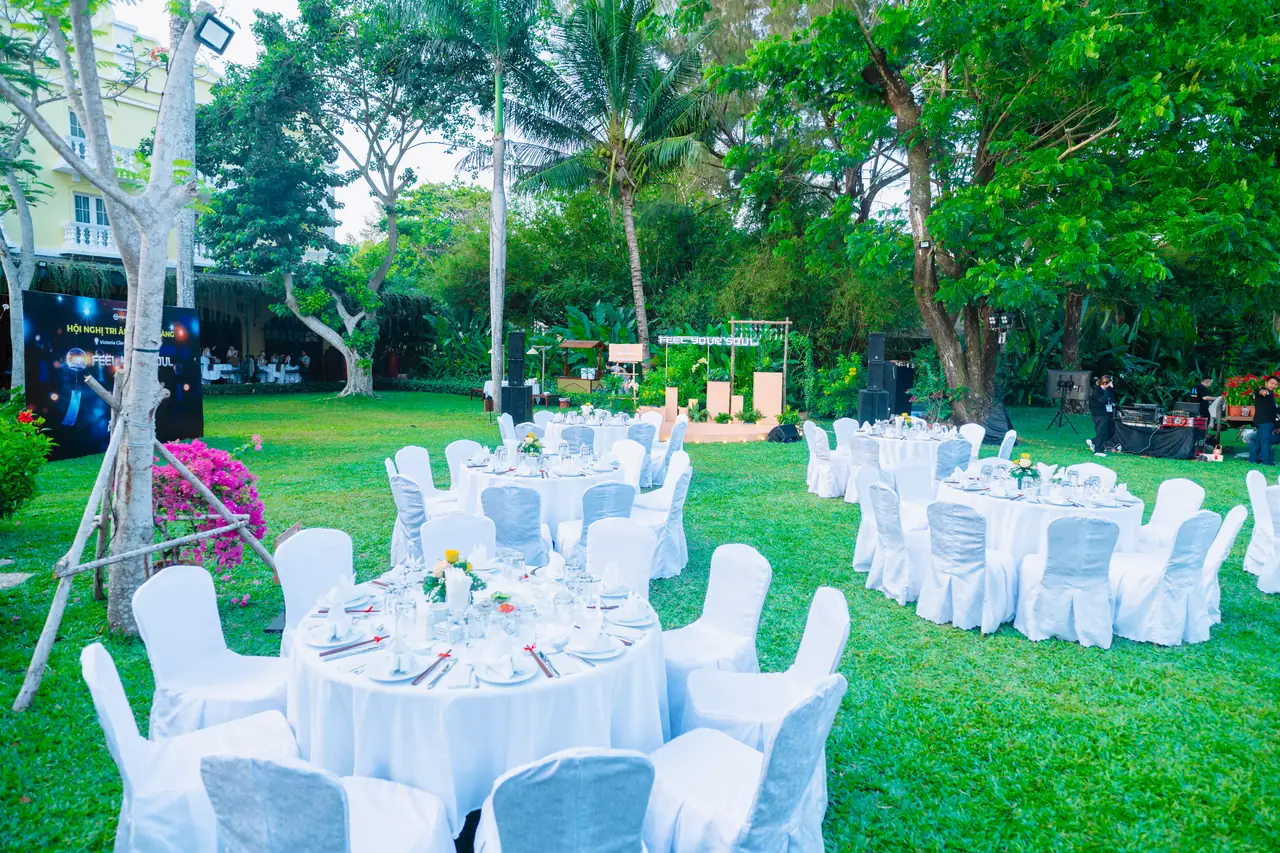 Bàn tiệc ngoài trời dựng trên bãi cỏ trong khuôn viên resort