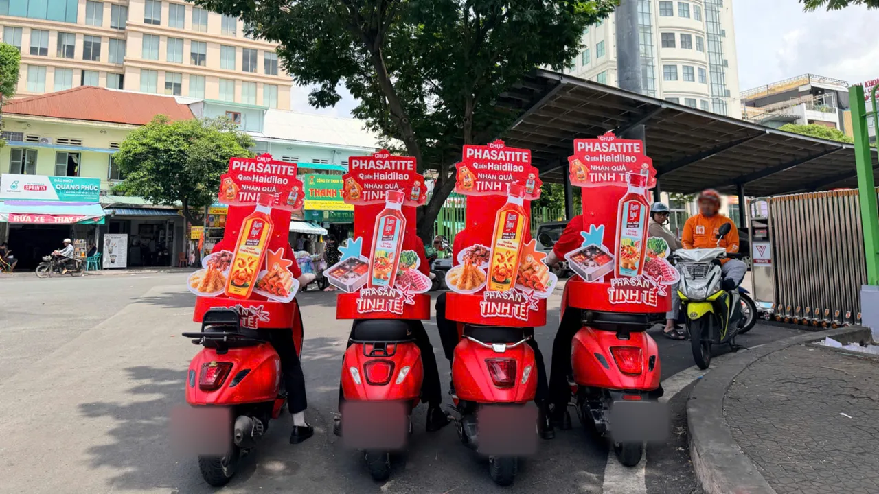 Bốn xe Vespa đỏ dán decal Nam Ngư Pha Sẵn Tinh Tế đỗ tại công viên 23 Tháng 9 trước giờ chạy roadshow