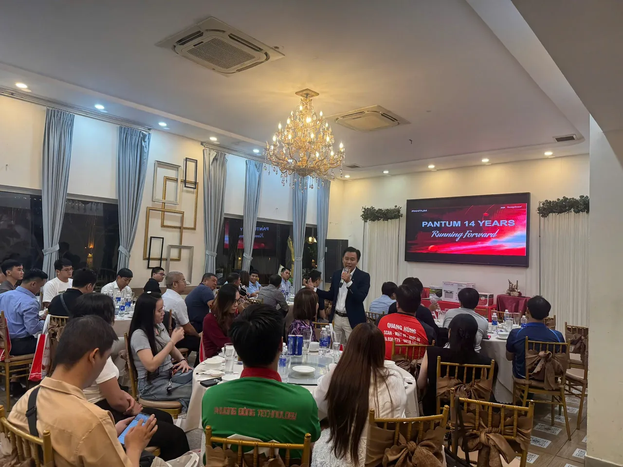 Hội trường bàn tròn của hội nghị Pantum & CyberPower, màn hình LED "Pantum 14 Years" phía trước và các đại lý ngồi theo bàn